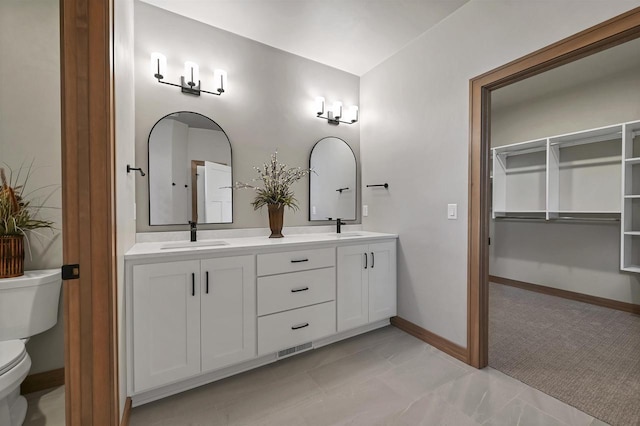 1629 N Honeysuckle Cir, De Pere, WI 54115 - bathroom featuring baseboards, double vanity, a sink, and toilet