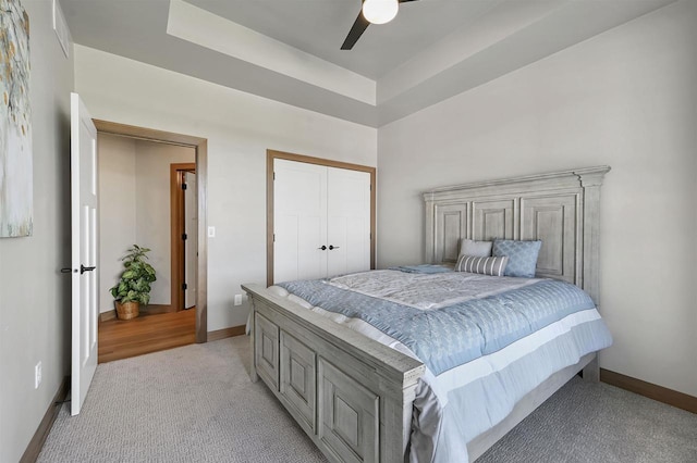 1629 N Honeysuckle Cir, De Pere, WI 54115 - bedroom featuring a closet, a ceiling fan, a raised ceiling, baseboards, and light colored carpet