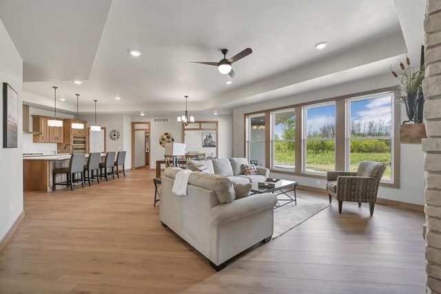 1629 N Honeysuckle Cir, De Pere, WI 54115 - living room with recessed lighting, ceiling fan with notable chandelier, baseboards, visible vents, and light wood-style flooring