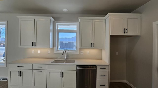 kitchen featuring dishwasher, a healthy amount of sunlight, white cabinetry, and a sink