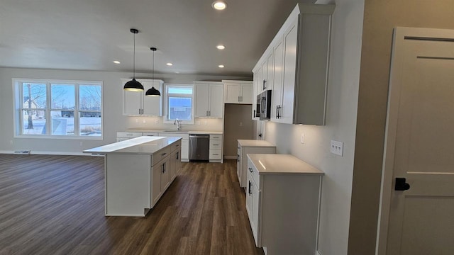 kitchen with a sink, a center island, dark wood-style floors, and stainless steel appliances