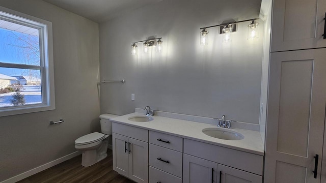 full bath with wood finished floors, toilet, baseboards, and a sink