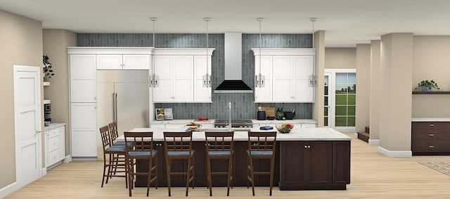 kitchen with pendant lighting, a center island with sink, a kitchen bar, and light hardwood / wood-style flooring