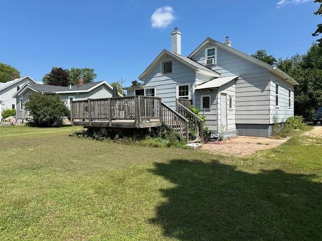 rear view of house featuring a yard and a wooden deck