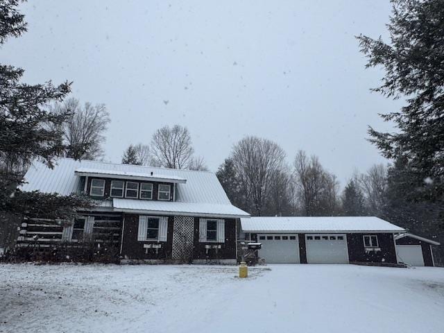 view of front of house featuring a garage, a front lawn, and an outdoor structure