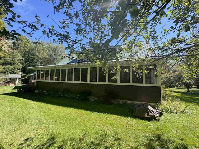 view of home's exterior featuring a lawn and a sunroom