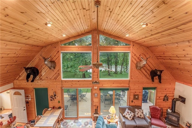 N1071 Ranch Rd, Holcombe, WI 54745 - living area featuring wooden ceiling, high vaulted ceiling, wood walls, and a wood stove
