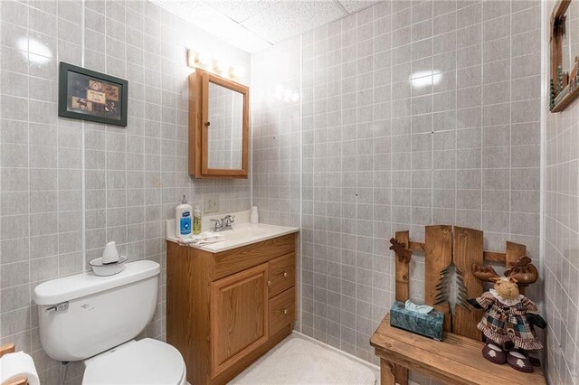 N1071 Ranch Rd, Holcombe, WI 54745 - half bath featuring toilet, vanity, and tile walls