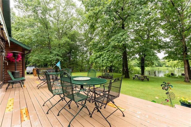 N1071 Ranch Rd, Holcombe, WI 54745 - wooden deck featuring outdoor dining area, a water view, and a lawn