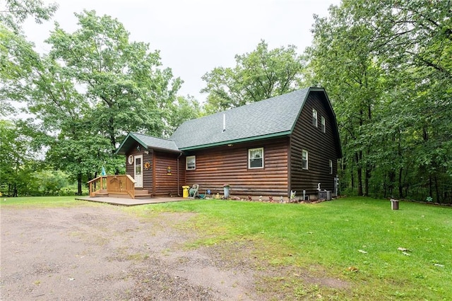 N1071 Ranch Rd, Holcombe, WI 54745 - rear view of property featuring faux log siding, roof with shingles, a wooden deck, central AC, and a yard