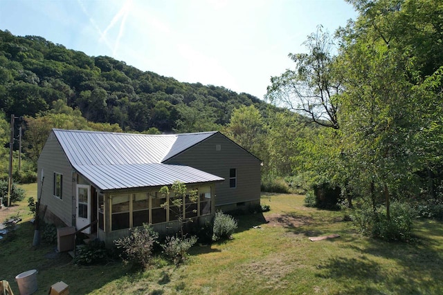 rear view of property with a yard and a sunroom