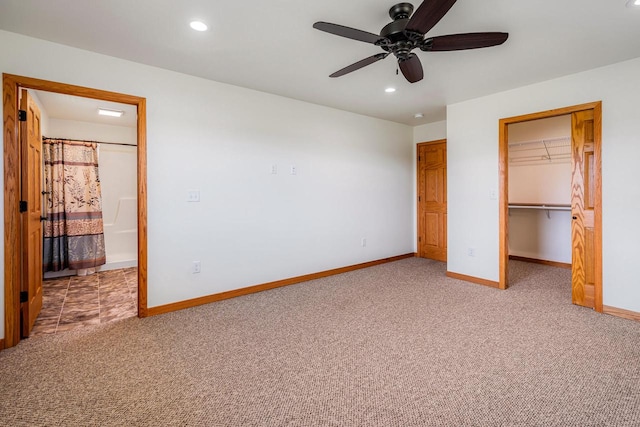 unfurnished bedroom featuring ceiling fan, a spacious closet, carpet flooring, connected bathroom, and a closet