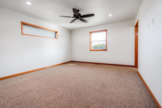 carpeted spare room featuring ceiling fan