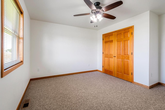 unfurnished bedroom with carpet floors, a closet, and ceiling fan