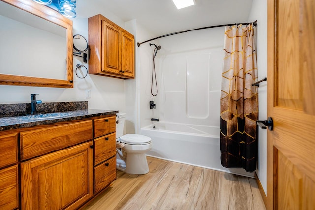 full bathroom featuring vanity, hardwood / wood-style floors, shower / tub combo with curtain, and toilet