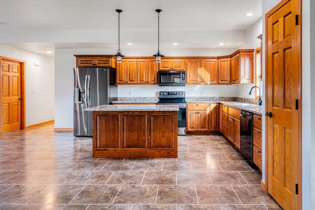 kitchen featuring light stone countertops, sink, black appliances, a center island, and decorative light fixtures