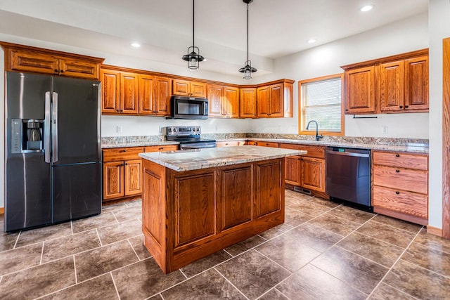 kitchen with appliances with stainless steel finishes, sink, a kitchen island, pendant lighting, and light stone counters