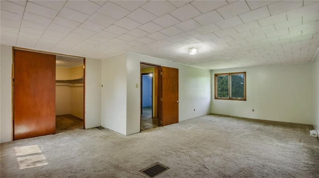 unfurnished bedroom with visible vents, carpet floors, and a closet