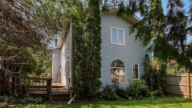 view of side of property featuring a deck and fence