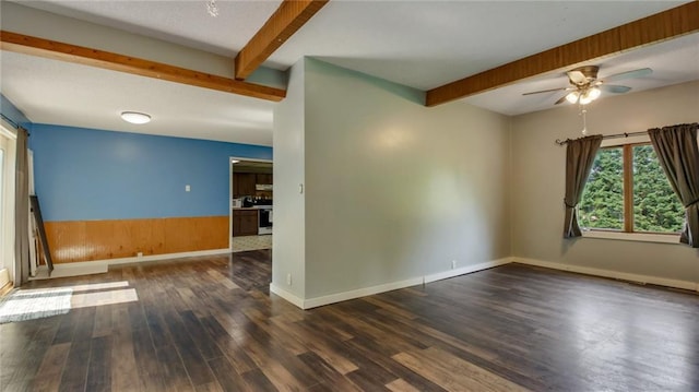 unfurnished room with baseboards, beam ceiling, wood finished floors, and a ceiling fan