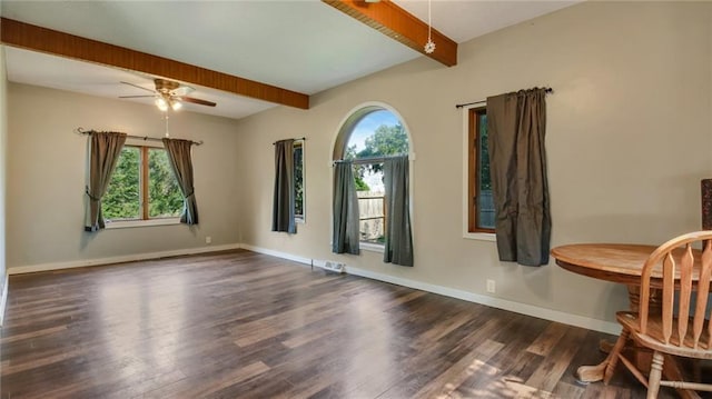 empty room with a ceiling fan, visible vents, wood finished floors, baseboards, and beamed ceiling