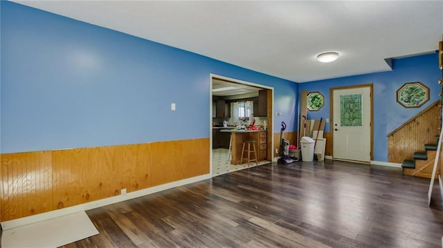 interior space featuring a wainscoted wall, wood finished floors, and stairs