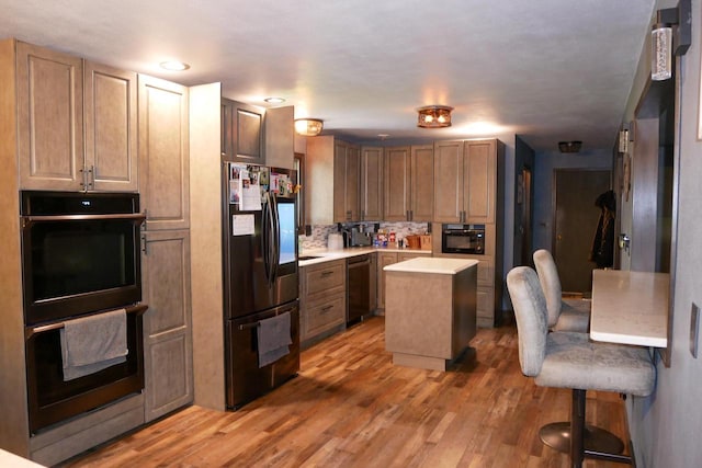 kitchen with black appliances, hardwood / wood-style flooring, a center island, and wine cooler