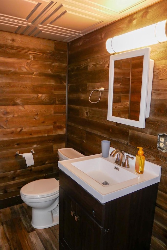 bathroom featuring vanity, toilet, wooden walls, and wood-type flooring