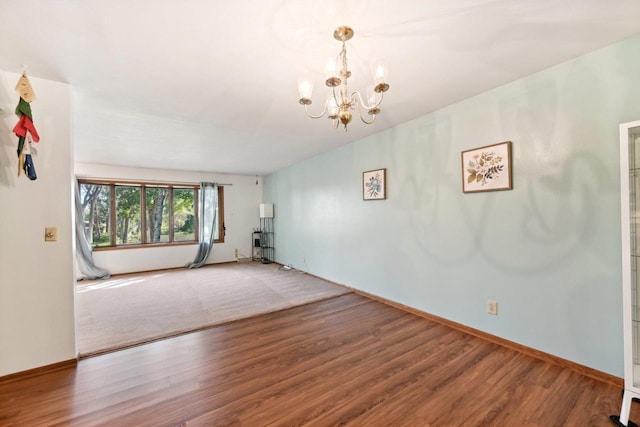 unfurnished room featuring wood-type flooring and a chandelier