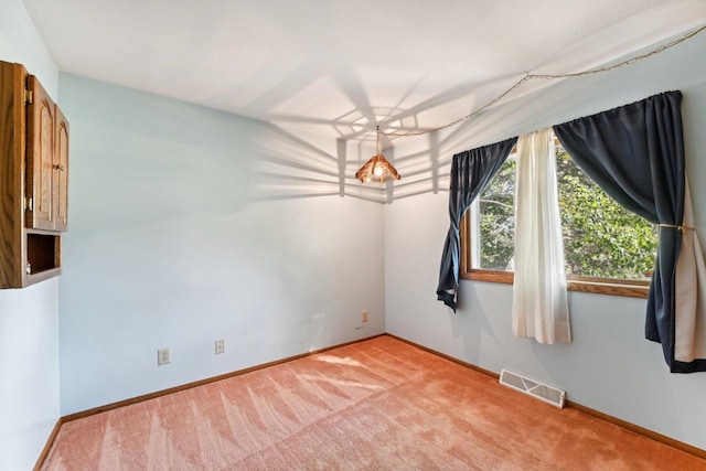 unfurnished room with light colored carpet, visible vents, and baseboards