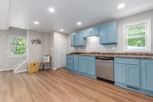 kitchen featuring plenty of natural light, light hardwood / wood-style flooring, stainless steel dishwasher, and blue cabinetry