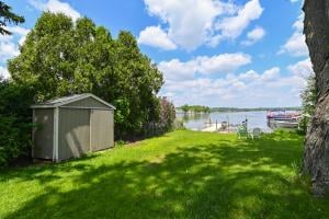 view of yard featuring a water view and a storage unit