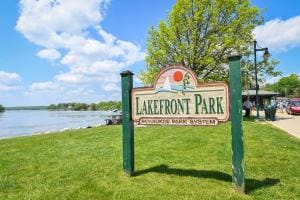 community sign featuring a water view and a lawn