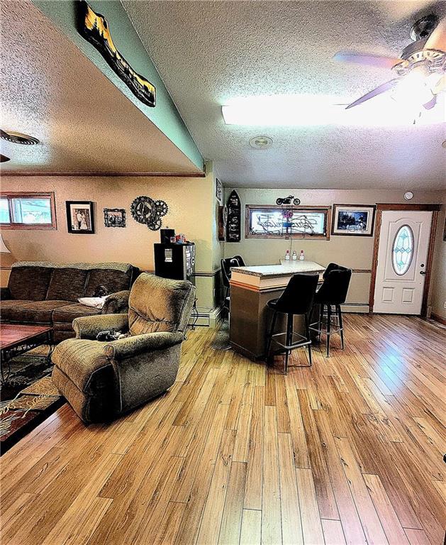 dining room featuring a textured ceiling, ceiling fan, and light hardwood / wood-style floors