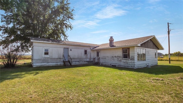 rear view of property with a yard