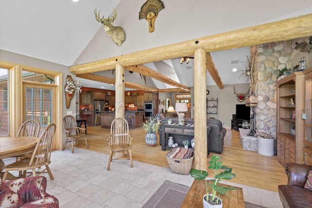 living room featuring light wood-style flooring, beamed ceiling, and high vaulted ceiling