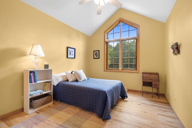 bedroom with ceiling fan, baseboards, lofted ceiling, and wood finished floors