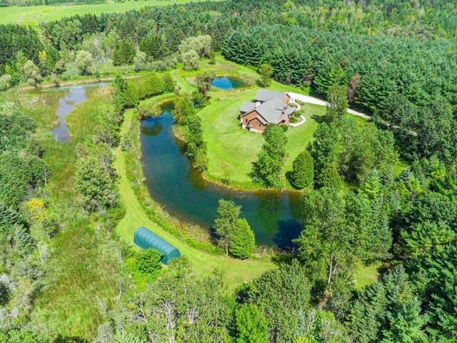 aerial view featuring a forest view and a water view