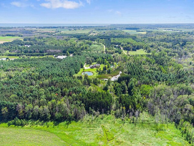 aerial view with a forest view and a water view