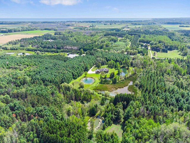 aerial view featuring a forest view and a water view