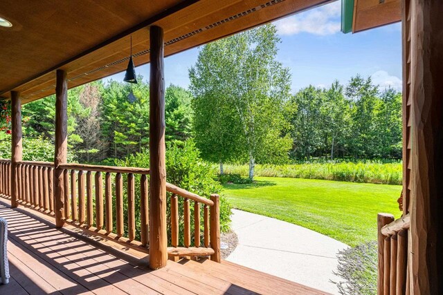 wooden terrace featuring a lawn