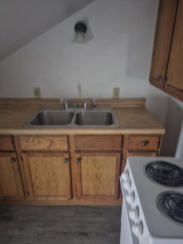 kitchen featuring a sink, brown cabinets, light countertops, and electric stove