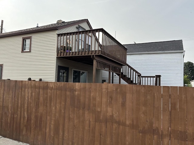 view of side of property featuring stairway, fence, and a wooden deck