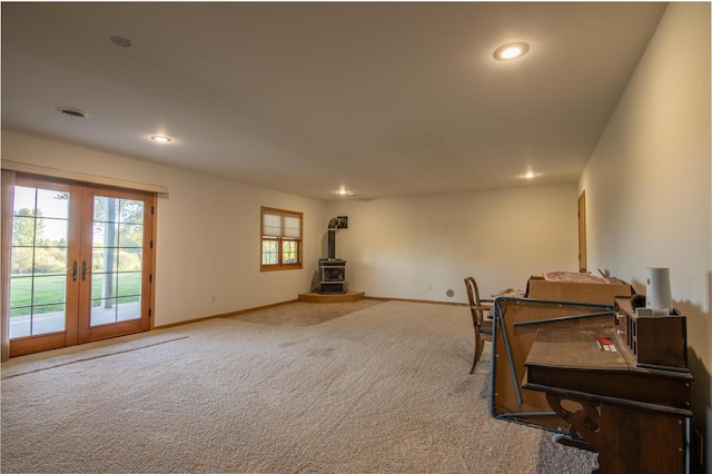 miscellaneous room featuring french doors, a wood stove, and carpet flooring