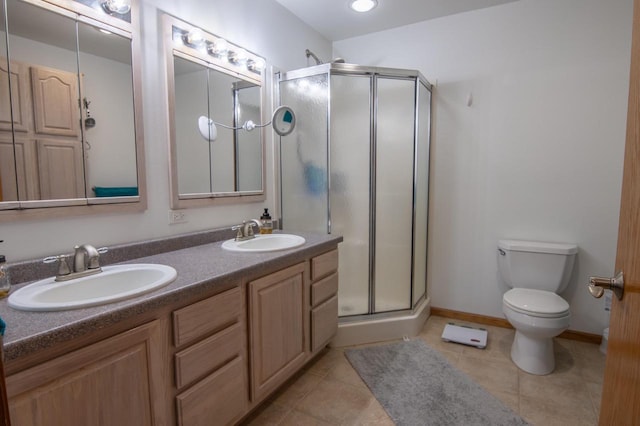 bathroom with tile patterned floors, vanity, toilet, and a shower with shower door