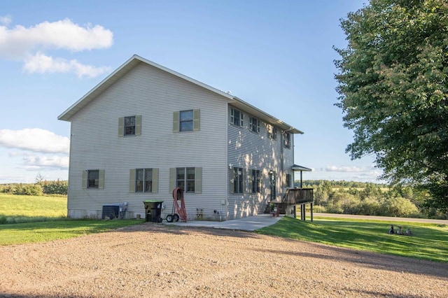 back of house featuring a lawn, a patio area, and central AC unit