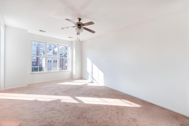 empty room featuring ceiling fan and light carpet