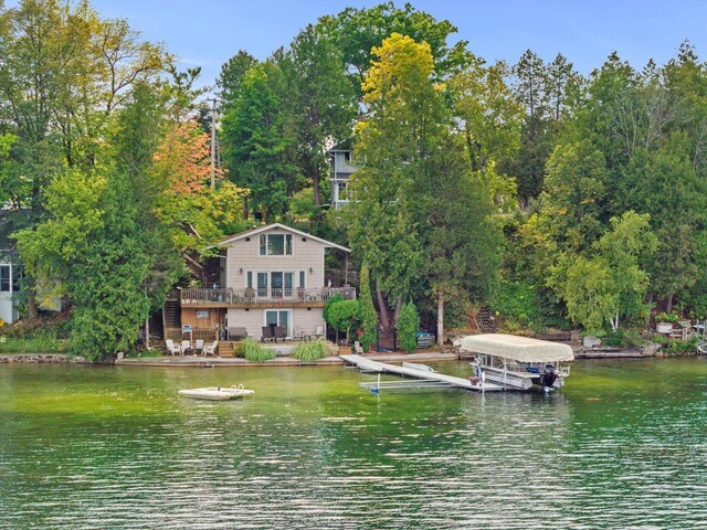 view of yard with a deck with water view and a fire pit