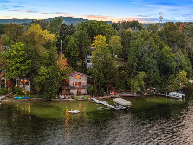 rear view of property featuring a deck with water view