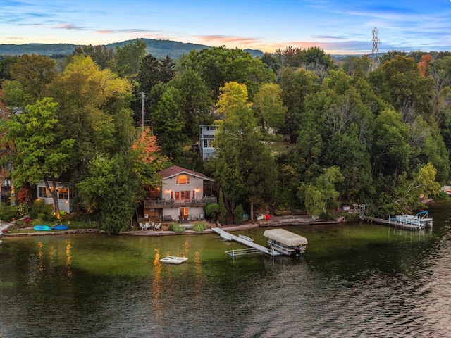 birds eye view of property featuring a wooded view and a water view